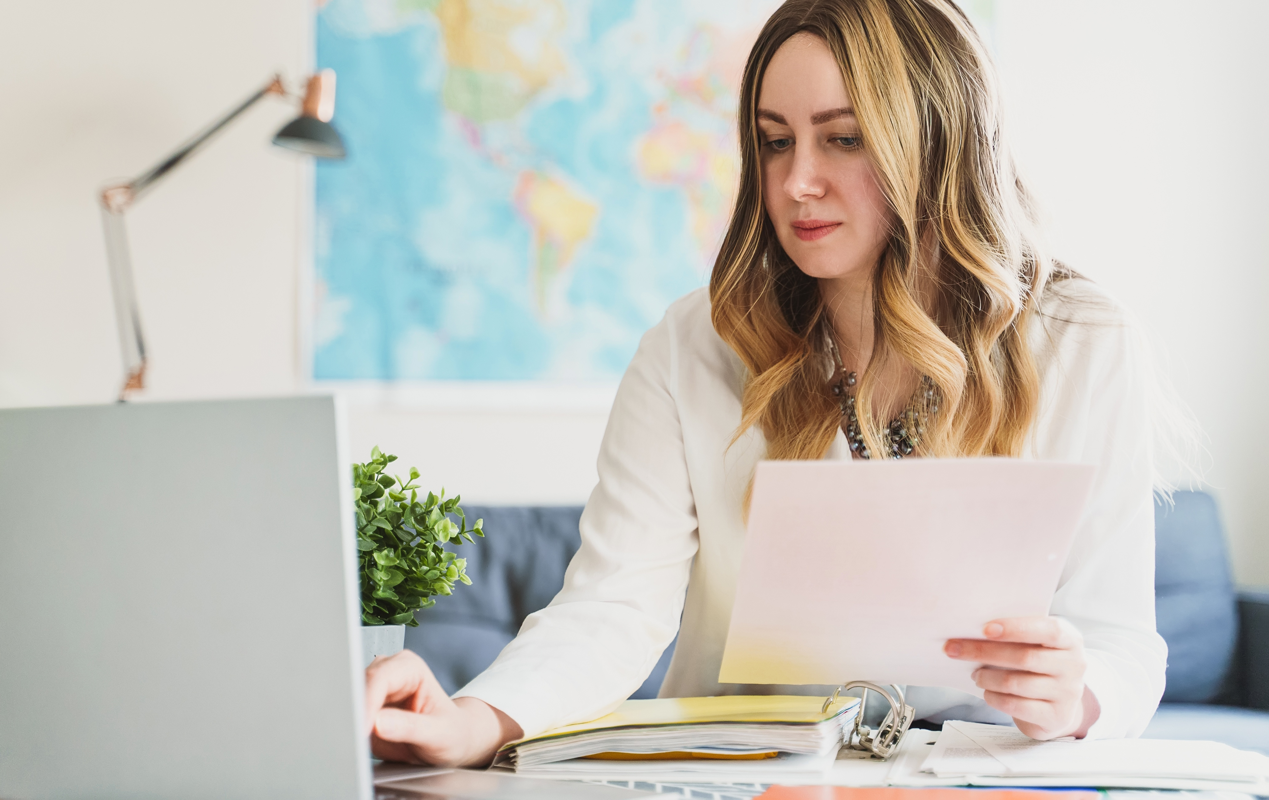 Travel agent working with papers and laptop