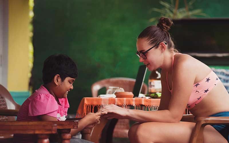 Young adult interacting with child in another country