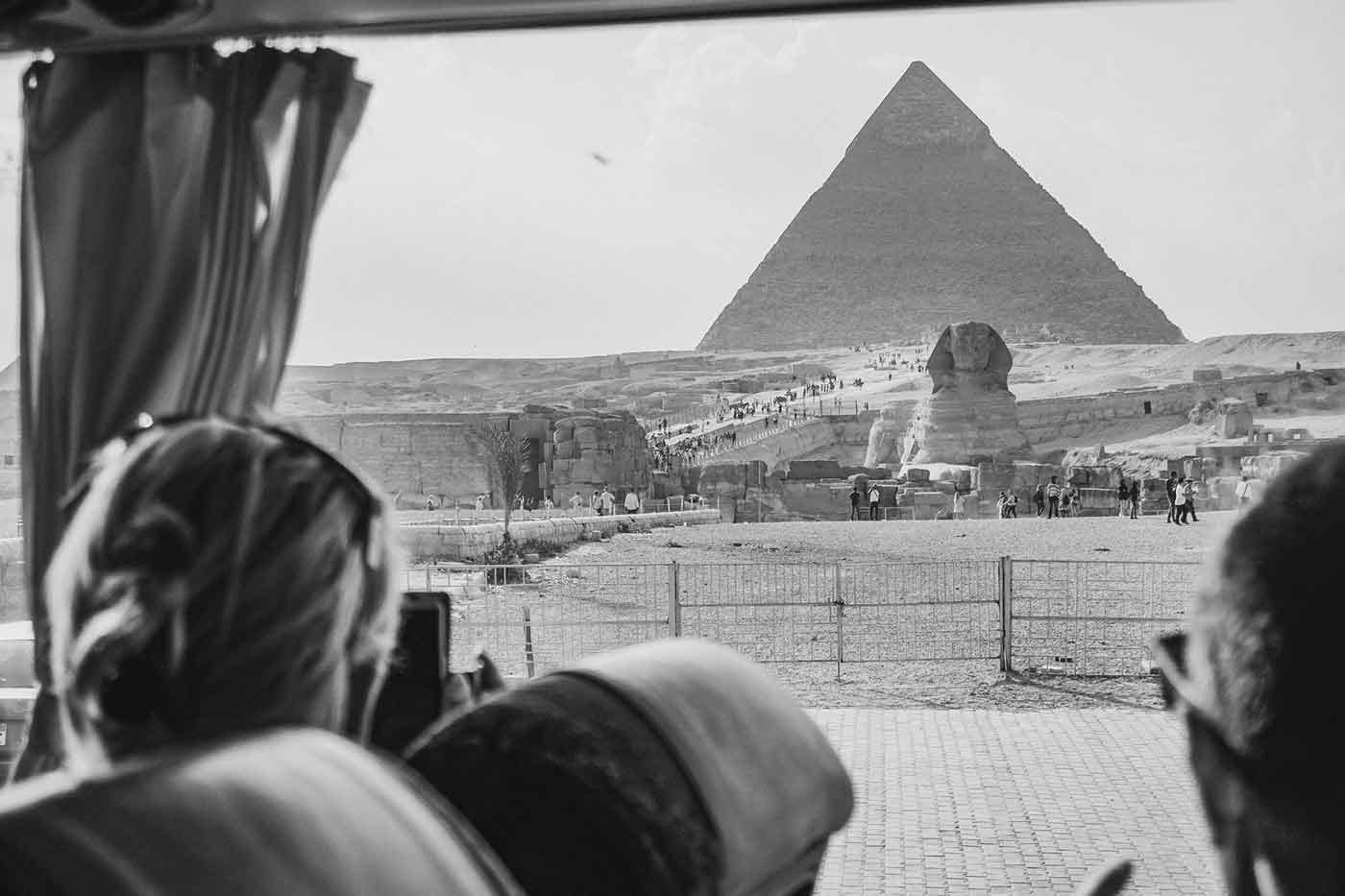 Tourists in bus looking at pyramids