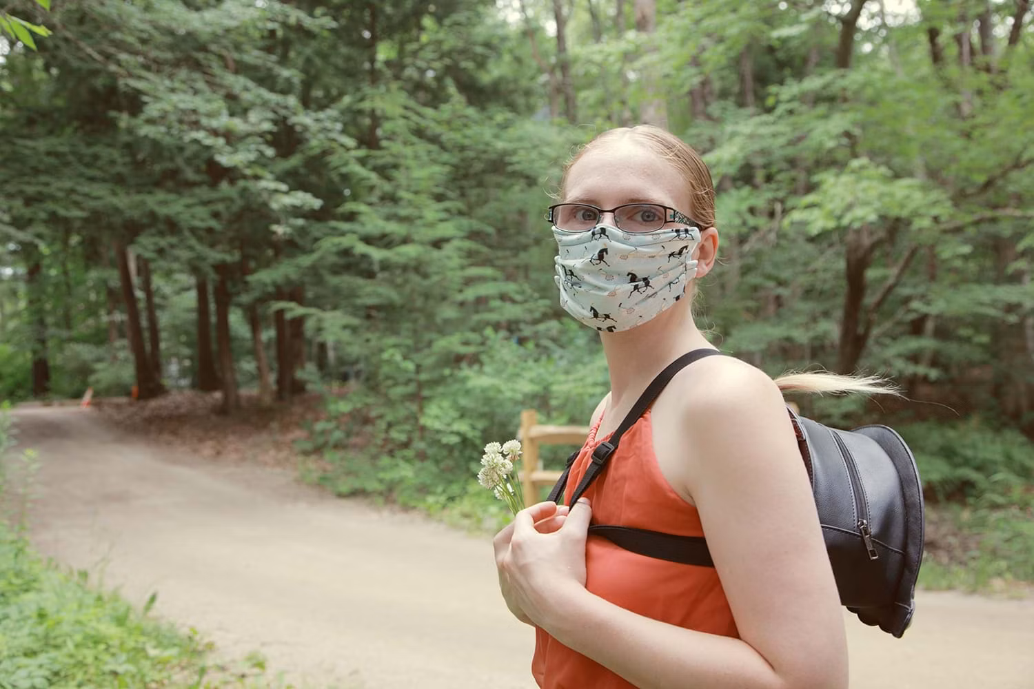 Woman in mask walking through woods