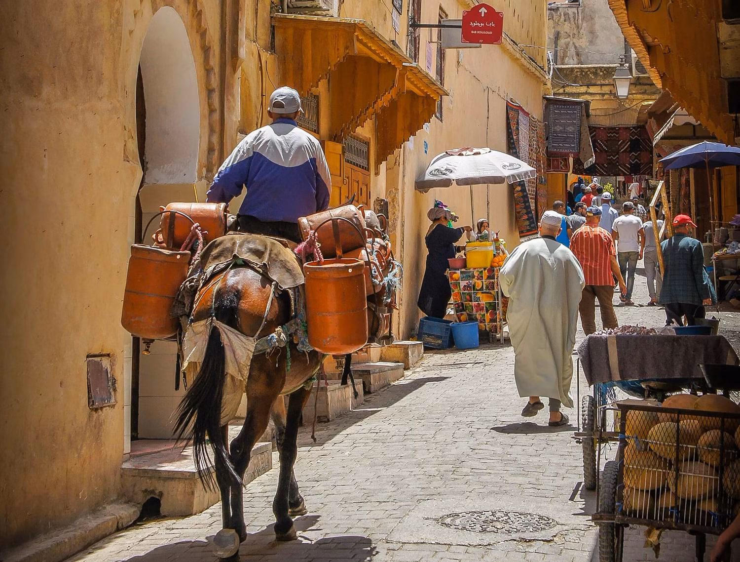 Man riding horse down side street