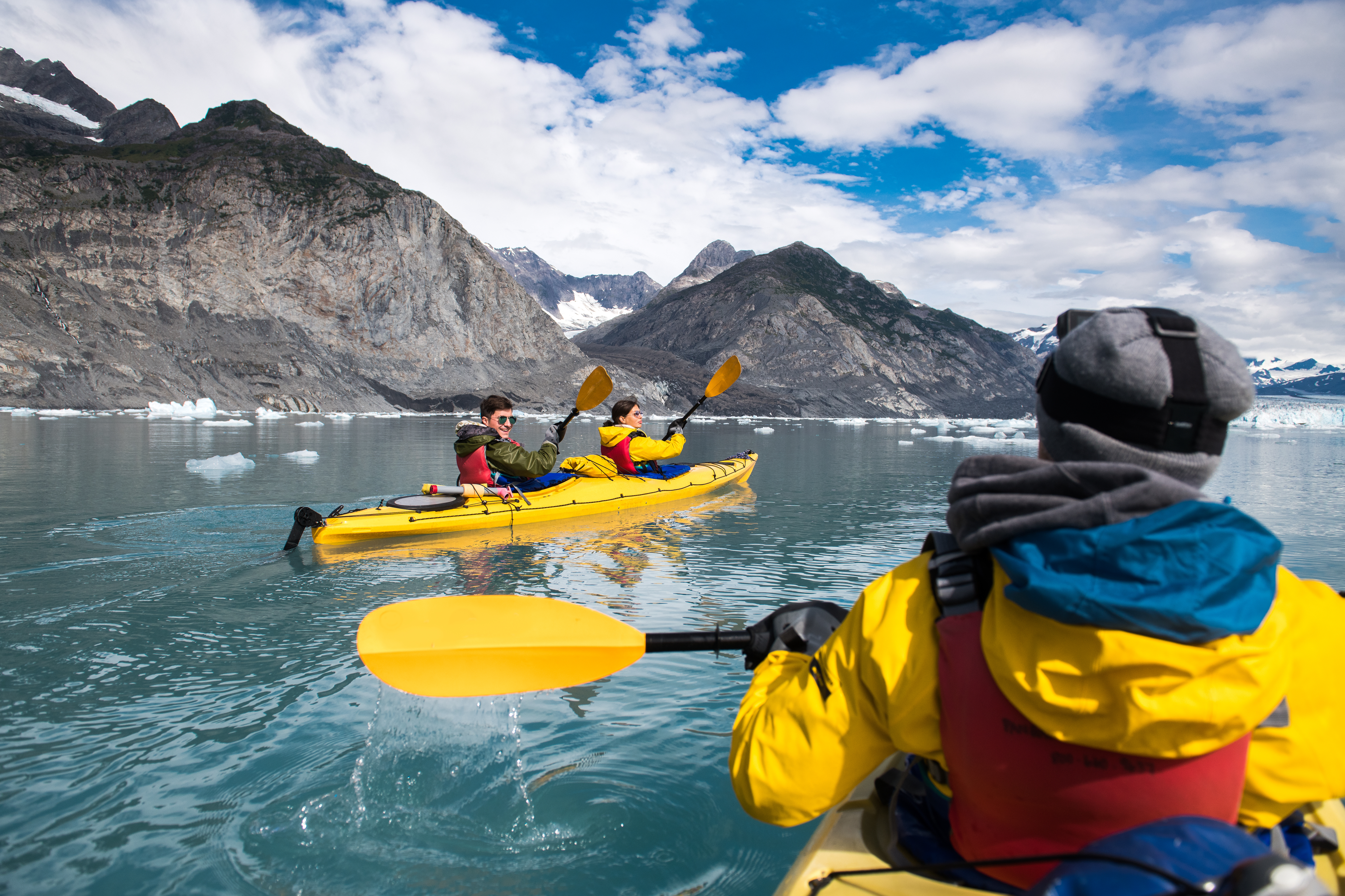 friends kayaking near glacier in Alaska